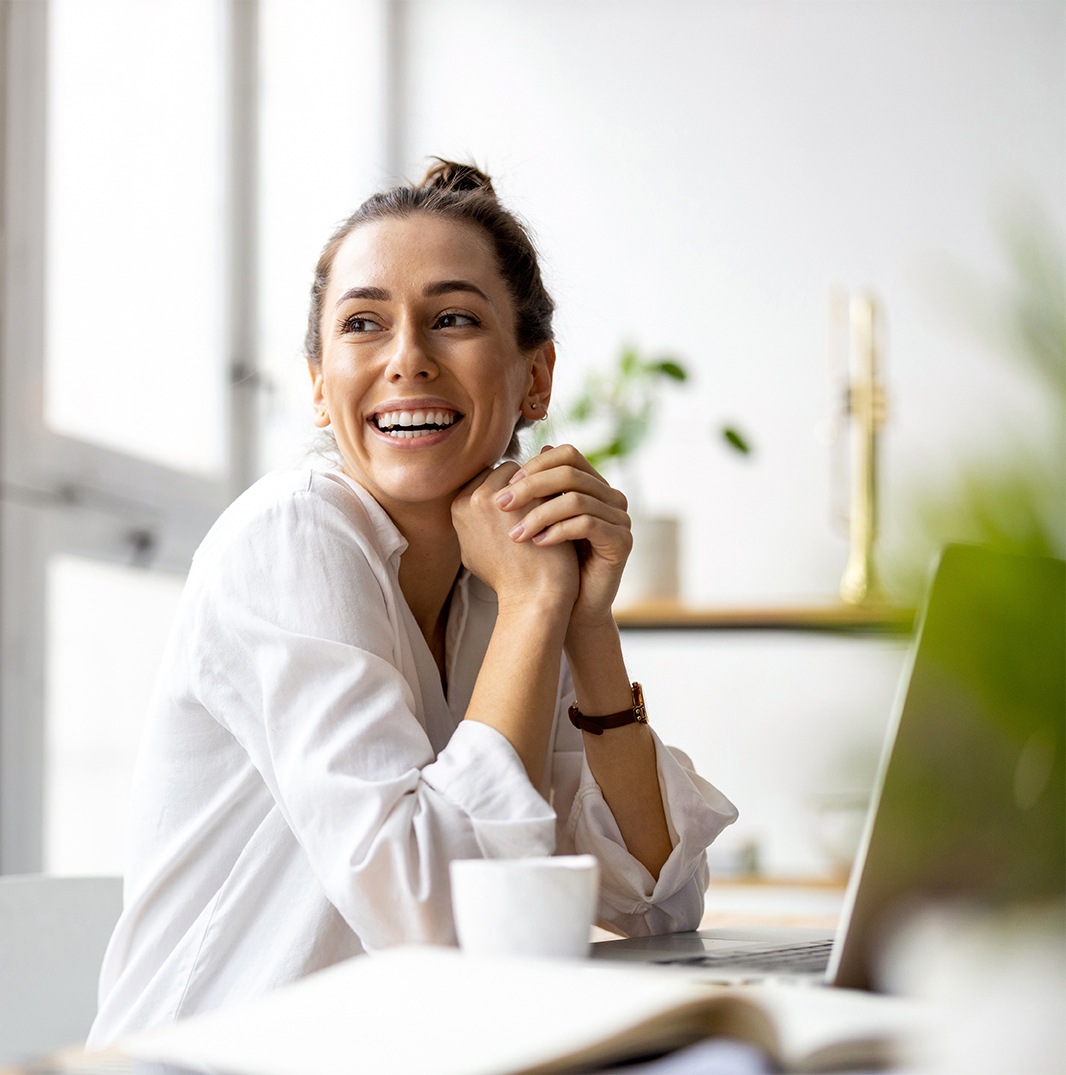 Individual smiling while working on their computer