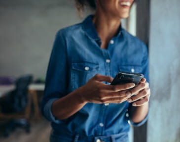 Person smiling while holding their mobile phone